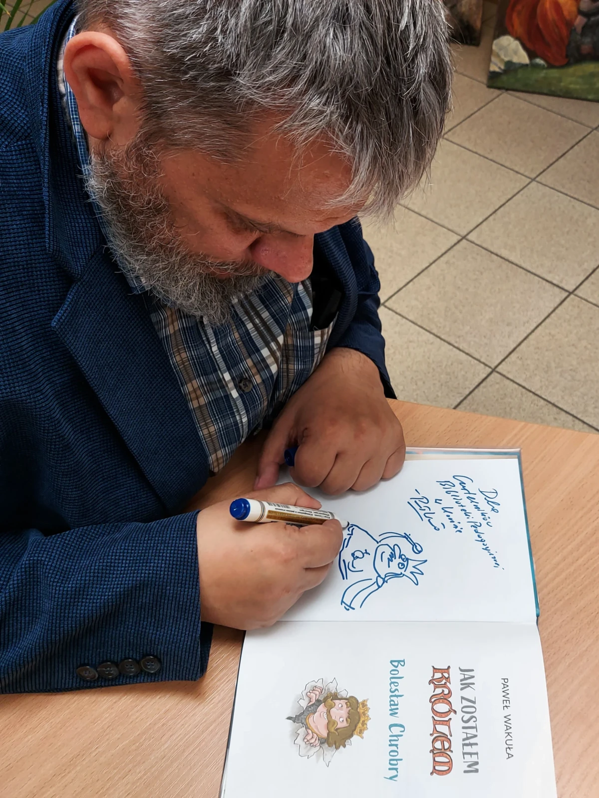 Autor podpisujący książki