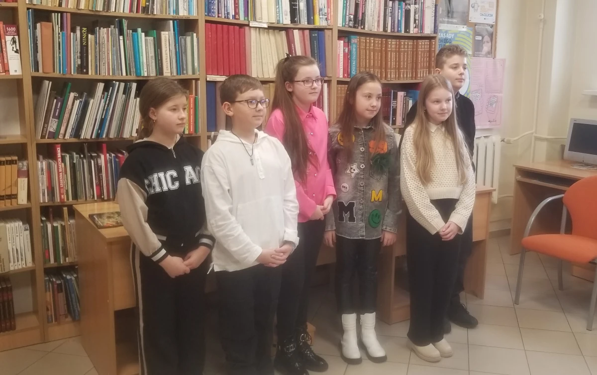 Dzieci na tle regału z książkami